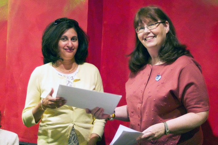 Lini Kadaba, left, accepts an award from contest chair Kay Stephens in 2013.